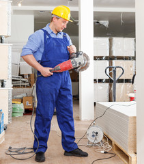 Builder working with handheld disc grinder