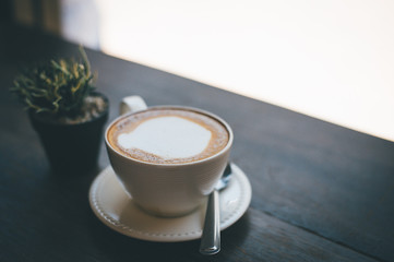 A cup of coffee and coffee beans on the table of coffee lovers coffee.