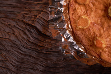 Apricot cake baked in foil on a wooden table. tasty pie food photo