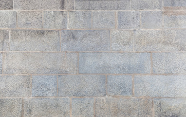 Full frame background of an old and aged wall made of stone blocks