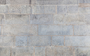 Full frame background of an old and aged wall made of stone blocks