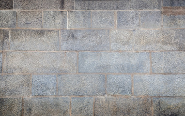 Full frame background of an old and aged wall made of stone blocks with vignette