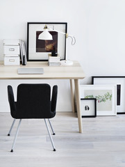 Chair standing near desk and pictures.