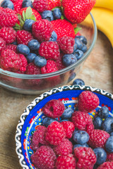 Top view of colorful healthy fresh fruits, bananas, apple, berries on an old rustic wooden table, Healthy summer diet or weight loss concept