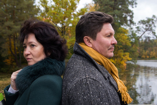 Middle-aged couple in the autumn forest. Expression of feelings.