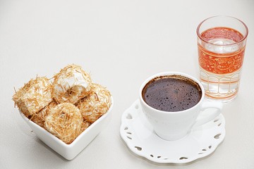 Turkish coffee with Shredded dough baked in syrup topped with crushed nuts Turkish delight and cup of water