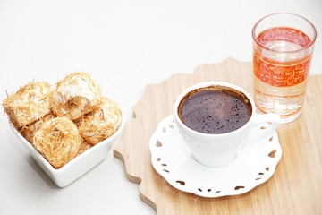 Turkish coffee with Shredded dough baked in syrup topped with crushed nuts Turkish delight and cup of water