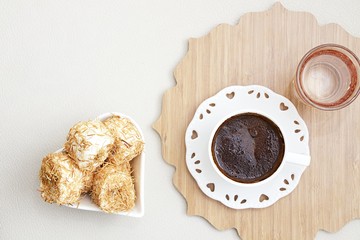 Turkish coffee with Shredded dough baked in syrup topped with crushed nuts Turkish delight and cup of water