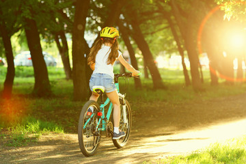 Girl riding a bike in the summer.