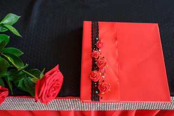 wedding decor red rose lies on the table and wish book for the newlyweds