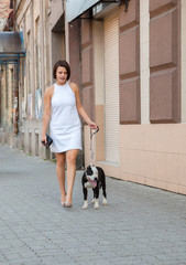 woman with a dog walking down the street