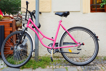 Fototapeta na wymiar Pink bicycle Bikes available for rental, parked in the city center.