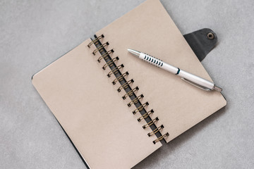 Open notebook with ballpen on grey background with copy space for text. Top view. Concept of of starting school, back to school, education