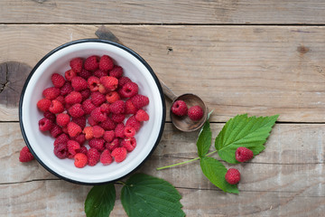 Raspberries on wooden table - food background with copy space