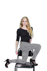 Fototapeta premium Beautiful blonde posing on chair. White background. Vertical photo.