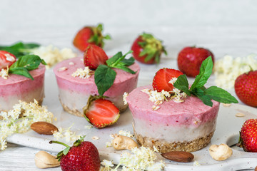 homemade raw strawberry cakes with fresh berries, mint, nuts and elder flowers. healthy vegan food