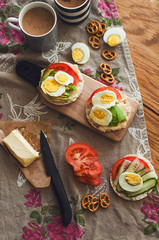 Fototapeta na wymiar Man holding crisp toast with avocado, cream butter and egg over table. Useful fat and nutritious. Healthy breakfast lunch snack