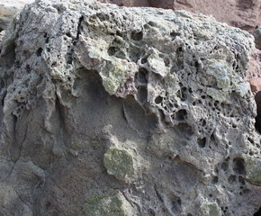 A natural stone of beautiful structure with cracks and interspersions close-up.