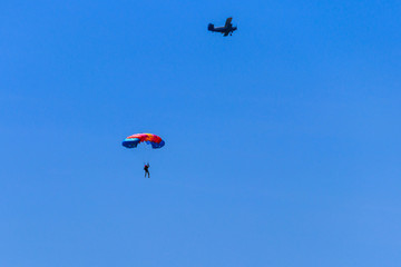 Naklejka na ściany i meble Parachutist and airplane in the blue sky. Active lifestyle. Extreme sport