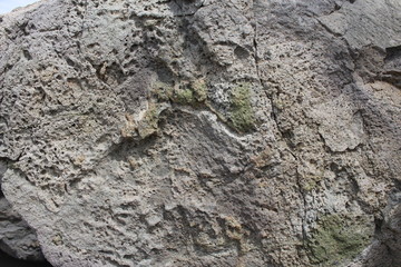 A natural stone of beautiful structure with cracks and interspersions close-up.