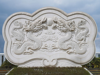 A Beautiful Sculpture or Monument of Two Dragons in A Public Area on Blue Sky and White Clouds Background.  This Is One of The Landmarks of Kunming City, Yunnan Province, China.