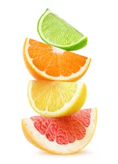 Zelfklevend Fotobehang Vruchten Geïsoleerde citrusschijfjes. Stukjes grapefruit, sinaasappel, citroen en limoenvruchten bovenop elkaar geïsoleerd op een witte achtergrond met uitknippad