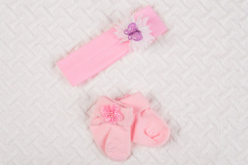 Baby socks and hair band for newborn on white blanket