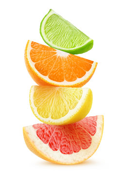 Isolated citrus slices. Pieces of grapefruit, orange, lemon and lime fruits on top of each other isolated on white background with clipping path