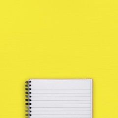 Notepad on yellow background top view