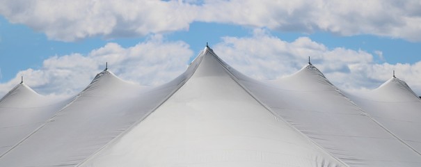 joyful image of a white events or wedding tent top with five peaks