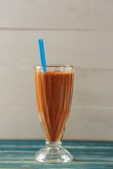 Smoothies chocolate on a light background with a straw