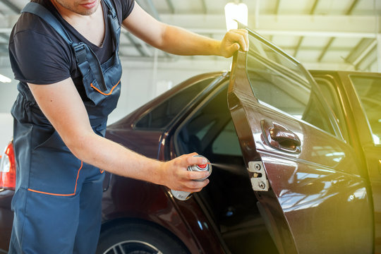 Mechanic Lubricates The Car, Repairs The Car Door, Lubrication Spray