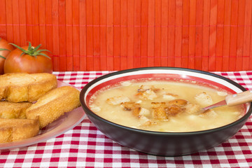 Sopa casera de caldo de verduras con trozos y rebanadas de pan frito
