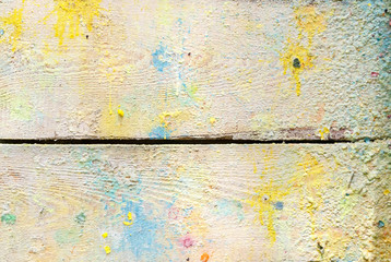 splashes and colored paint stains on the wall of old wooden planks after paintball. bright multicolored background