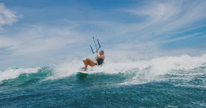 Beautiful young woman kitesurfing in the ocean