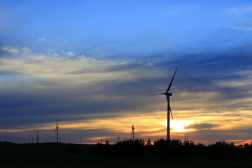 Obraz premium The silhouette of the windmill in the sunset