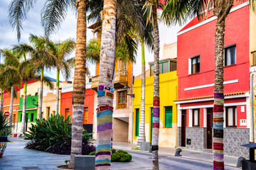Fototapeta na wymiar Colourful houses and palm trees on street in Puerto de la Cruz town, Tenerife, Canary Islands, Spain