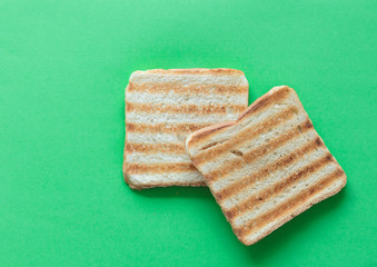 Slices of toast bread on green background, top view