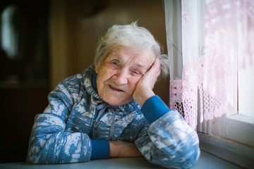 Portrait of an elderly woman in her house.