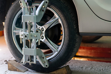 Car on stand with sensors on wheels for wheels alignment camber check in workshop of Service station