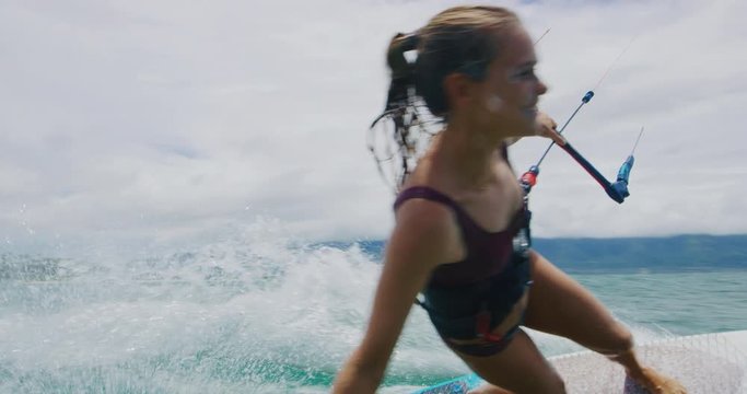 Beautiful young woman kitesurfing in slow motion