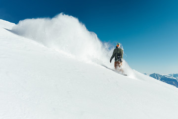 Fototapeta na wymiar snowboarder in gear brakes on slope freeride brakes creating a wave of snow