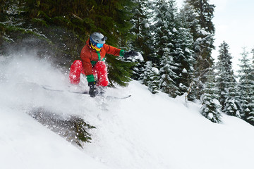 guy snowboarder rides freeride in the forest leaving behind spray of snow