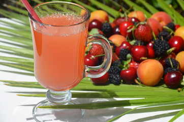 extremely close up glass of tasty tropical alcohol cocktail with berries or lemonade with beautiful decoration on a table in a restaurant with backgrounds of bright colored lights. soft focus.