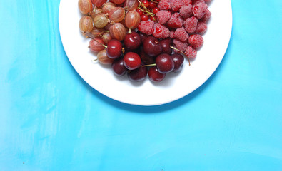 Plate of fruits. Currant, raspberry, gooseberry, cherries. 
