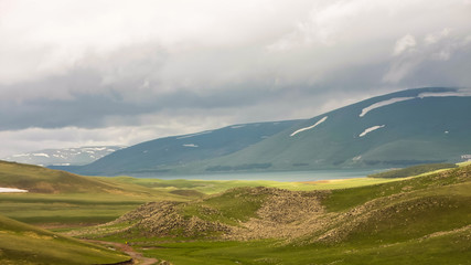 Fototapeta premium blue lake, green mountains, low clouds