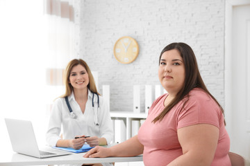 Female doctor and overweight woman in clinic