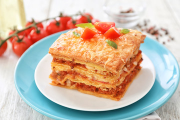 Plate with tasty lasagna on table