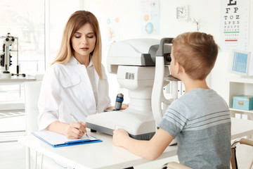 Obraz na płótnie Canvas Ophthalmologist examining little boy in clinic
