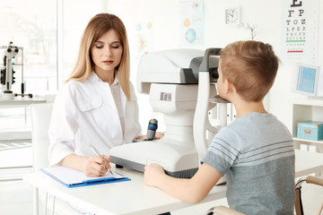 Fototapeta premium Ophthalmologist examining little boy in clinic